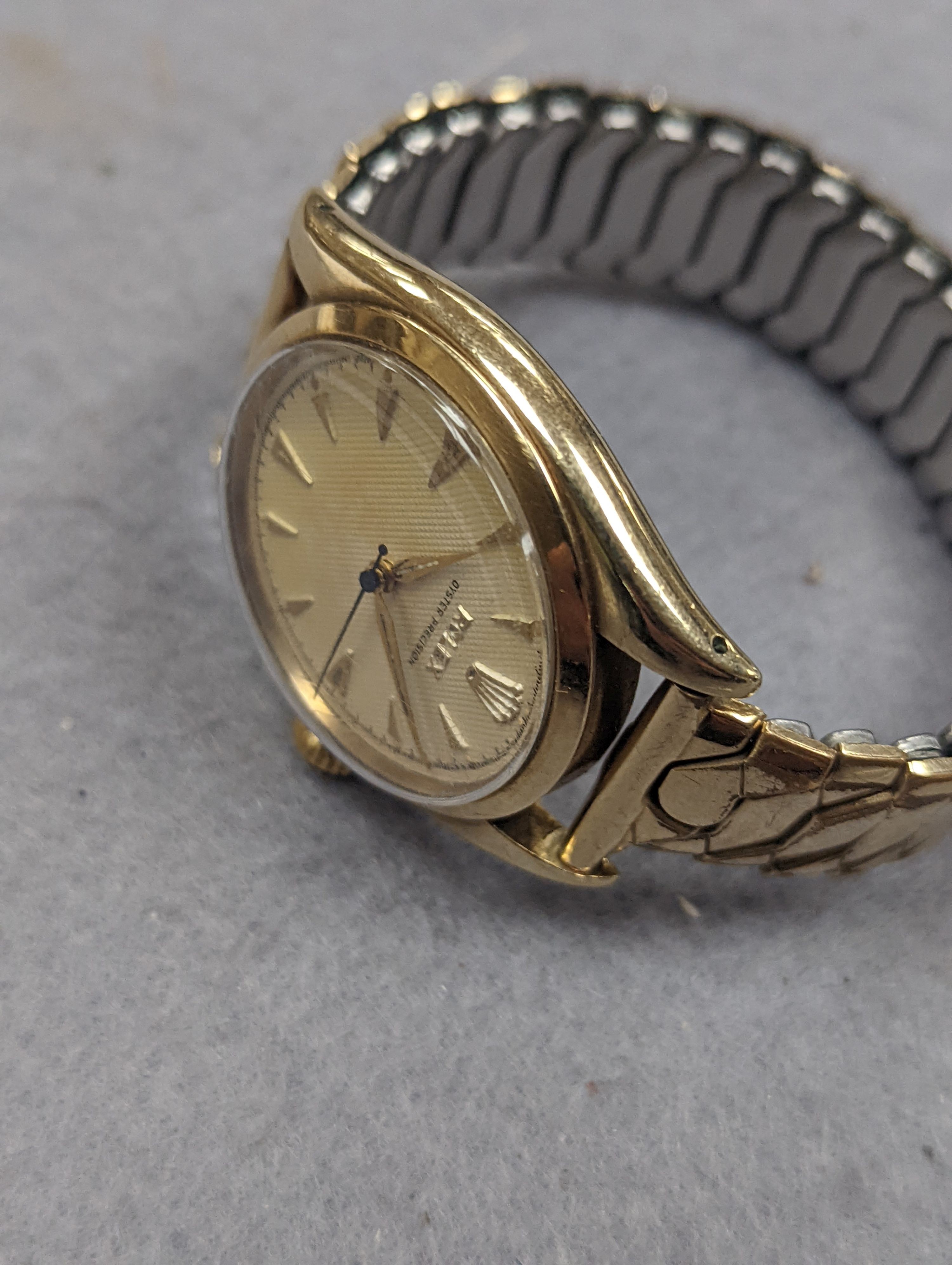 A gentleman's 1950's 9ct gold Rolex Oyster Precision manual wind wrist watch, with honeycomb dial and baton numerals, on associated expanding bracelet, case diameter 35mm, with personalised inscription to case back, no b